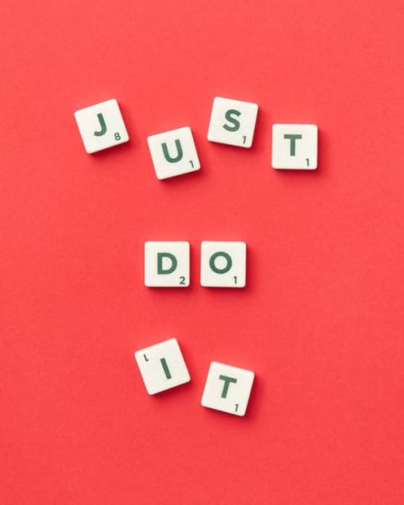 Motivational phrase 'Just Do It' spelled with Scrabble letters on a red background.